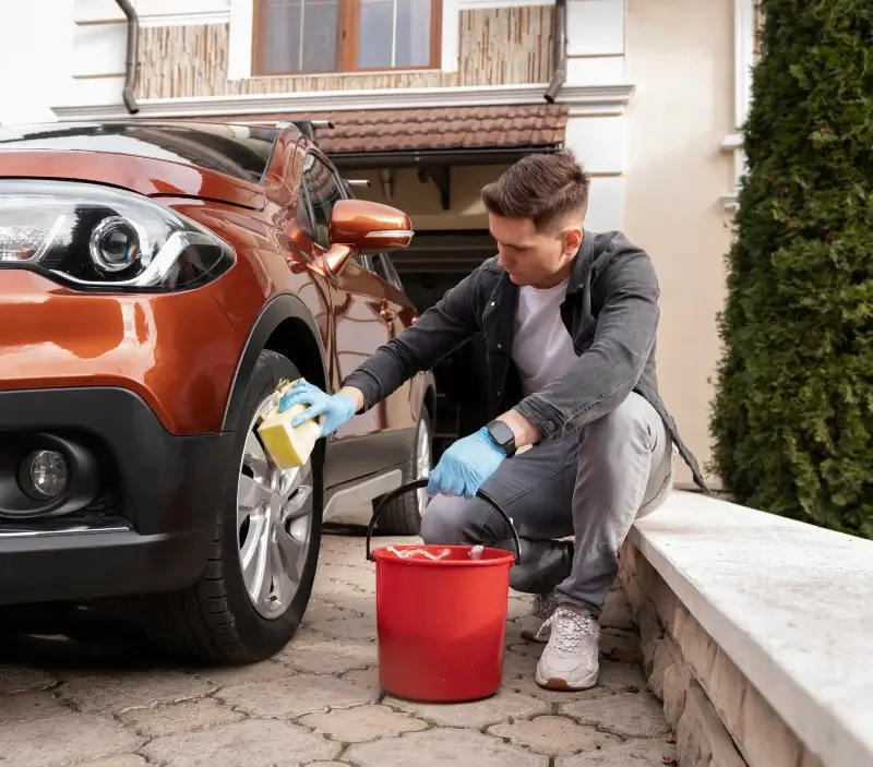 Lavage auto à domicile Sansac-de-Marmiesse : professionnel intervenant sur un véhicule